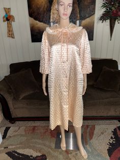 "1960's Vintage \"Vanity Fair\" Women Size Medium Peach Color Elegant Robe. This is a beautiful elegant robe that feels like silk against your skin. This is in MINT condition with NO tears or stains on the fabric Robe Details: 1.) Breast:42\" inches 2.) Shoulder to shoulder: 15\" inches 2.) Shoulder to hem: 43\" inches 4.) Sleeve Length: 23\" inches (Puffy Sleeves) 5.) Waist: 42\" inches 6.). Hip/ Thigh: 50\" inches 7.) 2 pockets 8.) 6 clear with floral design buttons 9.) 100% Acetate 10.) Label Silk Evening Robe For Spring, Vintage Long Robe For Daywear, Vintage Spring Loungewear Robe, Spring Vintage Robe For Loungewear, Long Vintage Silk Dress, Long Vintage Robe For Daywear, Spring Vintage Loungewear Robe, Vintage Long Fitted Robe, Vintage Long Sleeve Robe For Spring