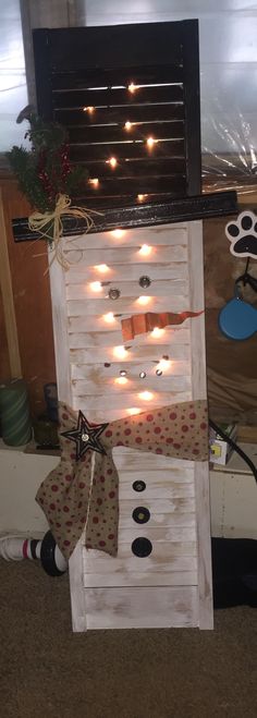 a snowman made out of wooden boards with lights on the top and around it