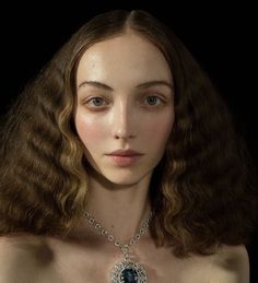 a woman with long brown hair wearing a necklace