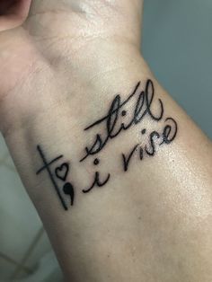 a wrist tattoo with the word still and rise written in cursive writing