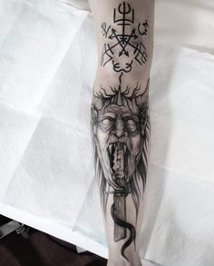 a person with a tattoo on their arm and leg, holding a knife in the other hand