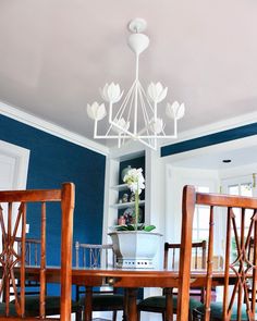 a dining room table with chairs and a potted plant in the center on top