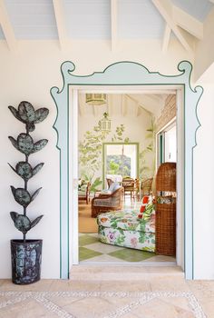 an open door leading to a living room with a couch and potted plant on the floor