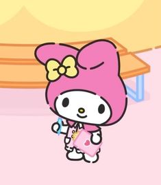 hello kitty is standing in front of a table with a pink bow on it's head