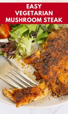 easy vegetarian mushroom steak on a white plate with a fork and salad in the background