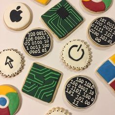 cookies decorated with computer symbols are displayed on a table