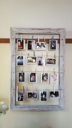 an old frame with photos hanging on it is hung on the wall above a table