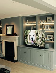 a flat screen tv sitting on top of a wooden shelf in front of a fireplace