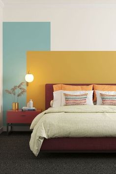 a large bed sitting in a bedroom next to a wall painted with different colors on it