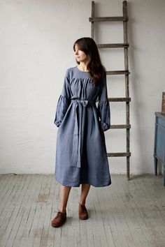 "Victorian dress is made from 100% soft and washed linen.  Details: - Colour: Dusty blue - Composition: 100% Oeko-Tex certified linen - Peach ribbon in the back - Ruffled long sleeves - Pockets - Belt included - Medium weight linen - Linen care: machine wash gentle; tumble dry low, ironing optional - The price is for one dress, other pictured items are not included The model is 173 cm/5'8\" and wears a size S." Blue Linen Midi Length Dress, Blue Midi Linen Dress, Blue Linen Long Sleeve Midi Dress, Blue Long Sleeve Linen Midi Dress, Blue Linen Dress With Pockets, Blue Linen Knee-length Dress With Relaxed Fit, Blue Knee-length Linen Dress With Relaxed Fit, Relaxed Fit Blue Linen Knee-length Dress, Blue Linen Long Sleeve Dress With Relaxed Fit