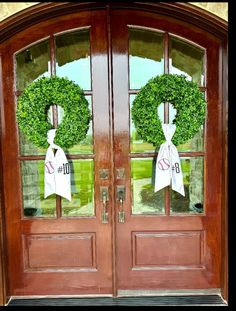 two wreaths are hanging on the front door