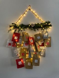 a christmas wreath made out of brown paper bags and lights on the wall above it