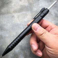 a person holding a pen in their left hand and pointing it at the other end