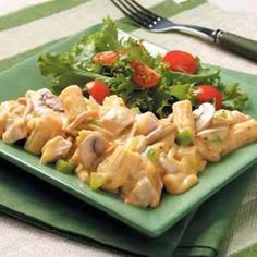 a green plate topped with chicken and salad