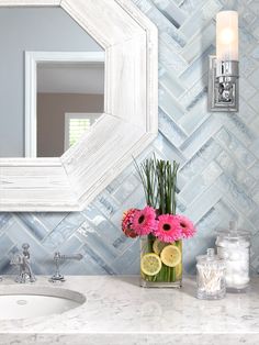 a vase with flowers and lemons on a bathroom counter