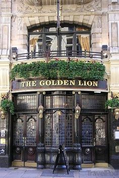 the golden lion pub in london is decorated with flowers and ivys on its balcony