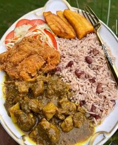 a white plate topped with rice, meat and veggies