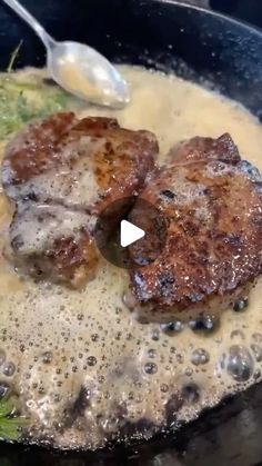 two meat patties are being cooked in a skillet with broth and gravy