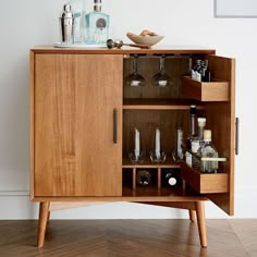 a wooden cabinet with wine glasses and liquor bottles