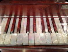 an old piano with marble tiles on it's keys and wood grained edges