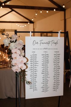 a sign that is on top of a table with flowers in it and some candles