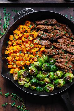 steak, brussel sprouts and sweet potatoes in a cast iron skillet