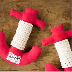 two red and white dog toys sitting on top of a wooden table