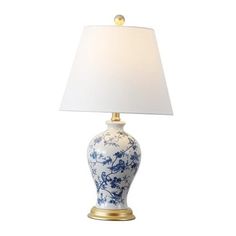 a blue and white vase lamp with a gold base on a white table cloth shade