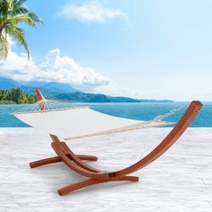 a white hammock sitting on top of a wooden stand next to the ocean