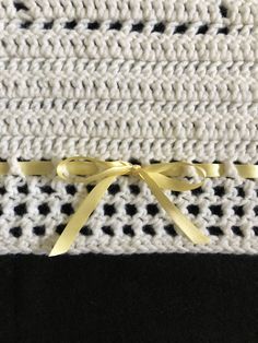 the yellow ribbon is attached to the black and white knitted material that has been stitched together