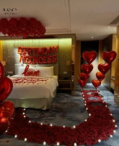 a bedroom decorated with red balloons and streamers