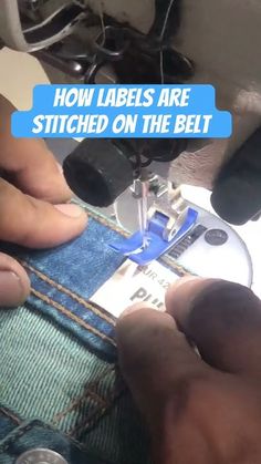 someone is stitching the label on a pair of jeans with a sewing machine in front of them