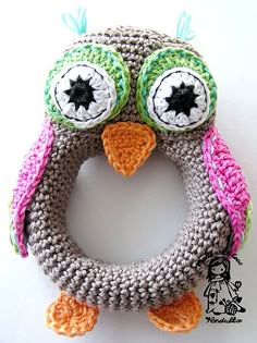 an owl crocheted ring with two eyes and a star on the top, sitting on a white surface