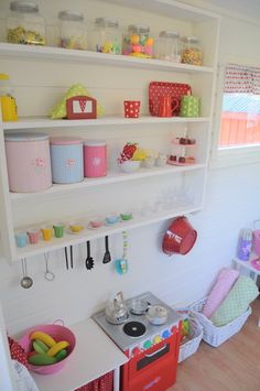 a kitchen with shelves filled with pots, pans and utensils on top of them