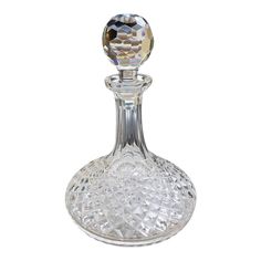 a clear glass bottle with a crystal ball in the top and bottom part, on a white background