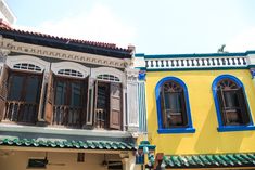 two buildings with blue and yellow shutters on the windows