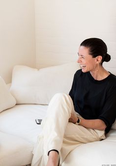 a woman sitting on top of a white couch