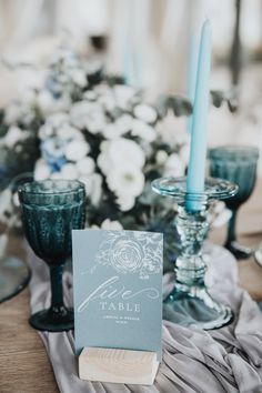 the table is set with candles and place cards