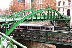 a green bridge with a train going over it