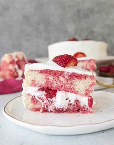 a piece of cake with white frosting and strawberries on top