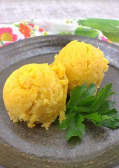 two pieces of food on a plate with parsley sprinkled on top and another item in the background