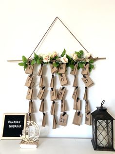 a bunch of tags hanging from a wall with flowers and leaves attached to the strings