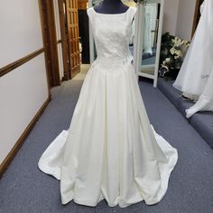 a white wedding dress on display in a bridal room