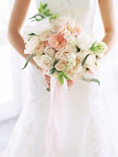 a bride holding a bouquet of flowers in her hands