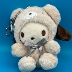 a stuffed animal with a keychain around it's neck on a blue background