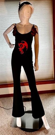 a mannequin dressed in black and red with a dragon on it's chest