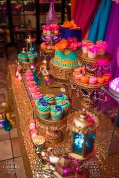 a table topped with lots of cupcakes and cakes