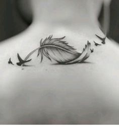 the back of a woman's neck with birds flying around and a feather on it