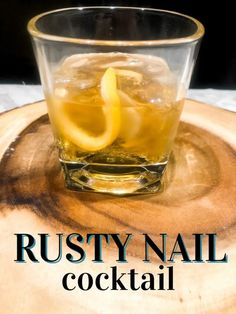 a glass filled with ice and lemon wedges on top of a wooden board that says rusty nail cocktail