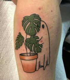 a tattoo on the leg of a person with a potted plant